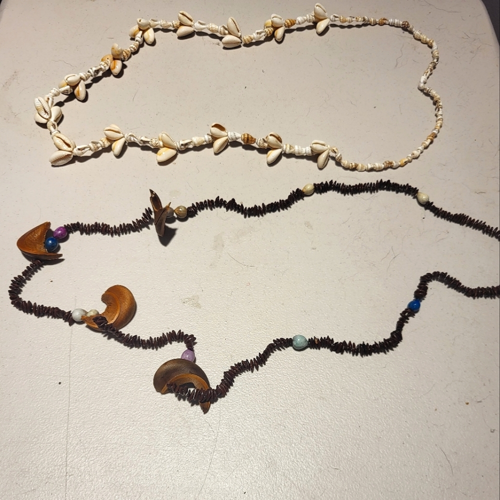 A pair of handmade necklaces;a seashell necklace & tribal styled necklace.
